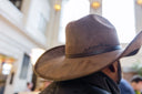 Person wearing a cowboy hat indoors with blurred background