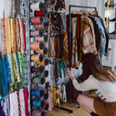 woman browsing fabric and hat bands