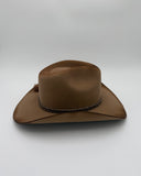 Brown wool felt cowboy hat with a braided band on a light gray background
