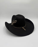 Detail shot of black suede cowboy hat with a feather, band and brim edge by Gem Hats