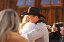 Man in a cowboy hat embracing a woman with a blurred background